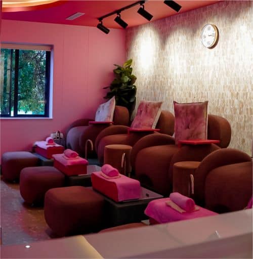 Modern nail salon chairs with foot baths, pink towels, and relaxing ambiance at The Pink Room.